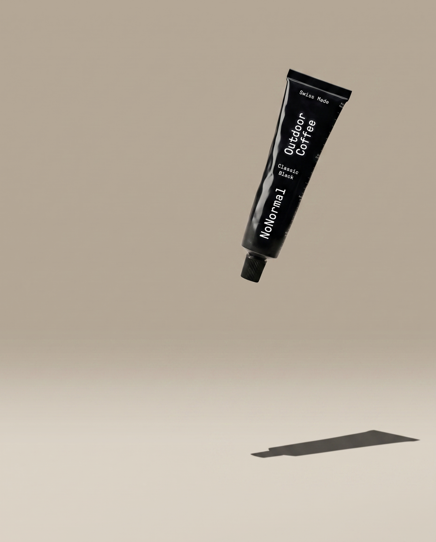 NoNormal Classic Black tube floating over a warm greige studio ground