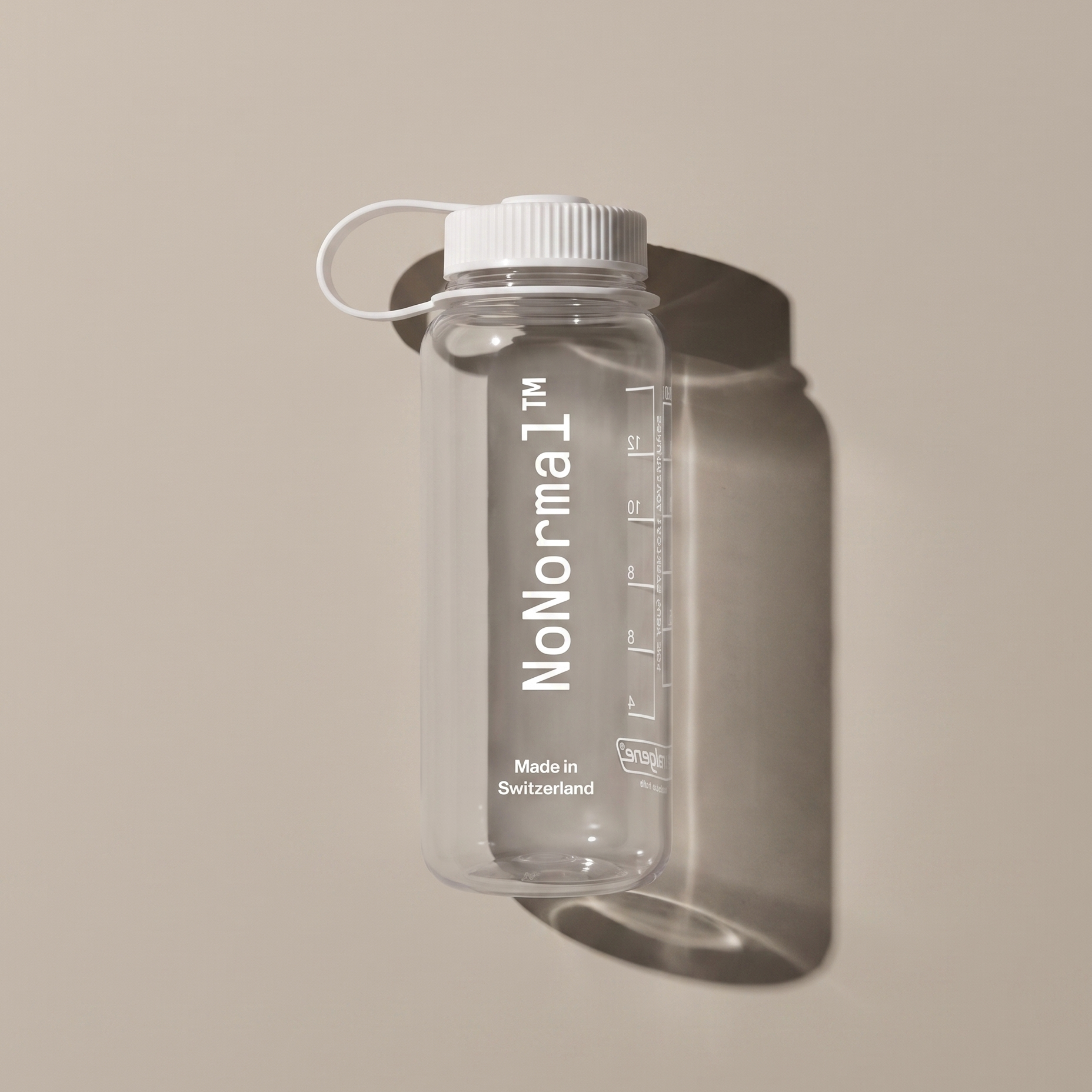 A clear plastic water bottle with a white screw cap and carrying loop, featuring the vertical 'NoNormal' branding and measurement markings, shown against a warm beige background with a soft shadow.
