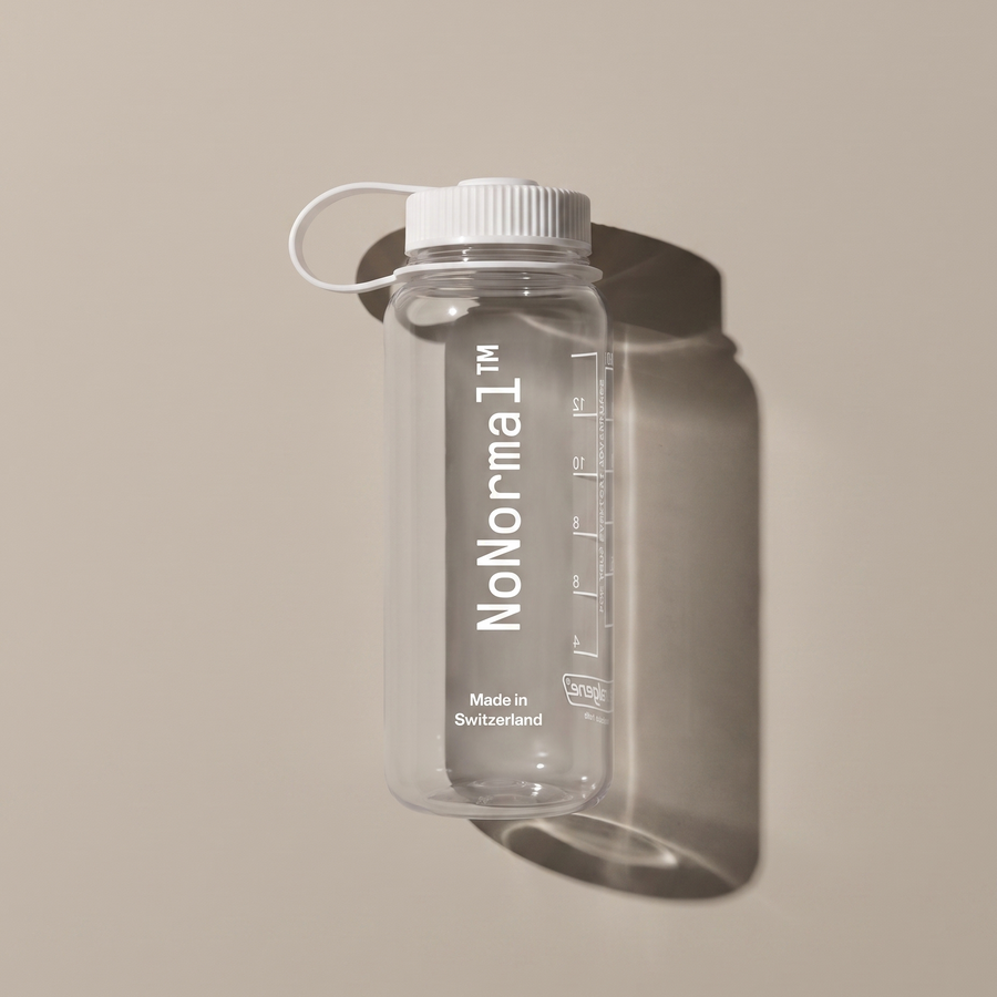 A clear plastic water bottle with a white screw cap and carrying loop, featuring the vertical 'NoNormal' branding and measurement markings, shown against a warm beige background with a soft shadow.