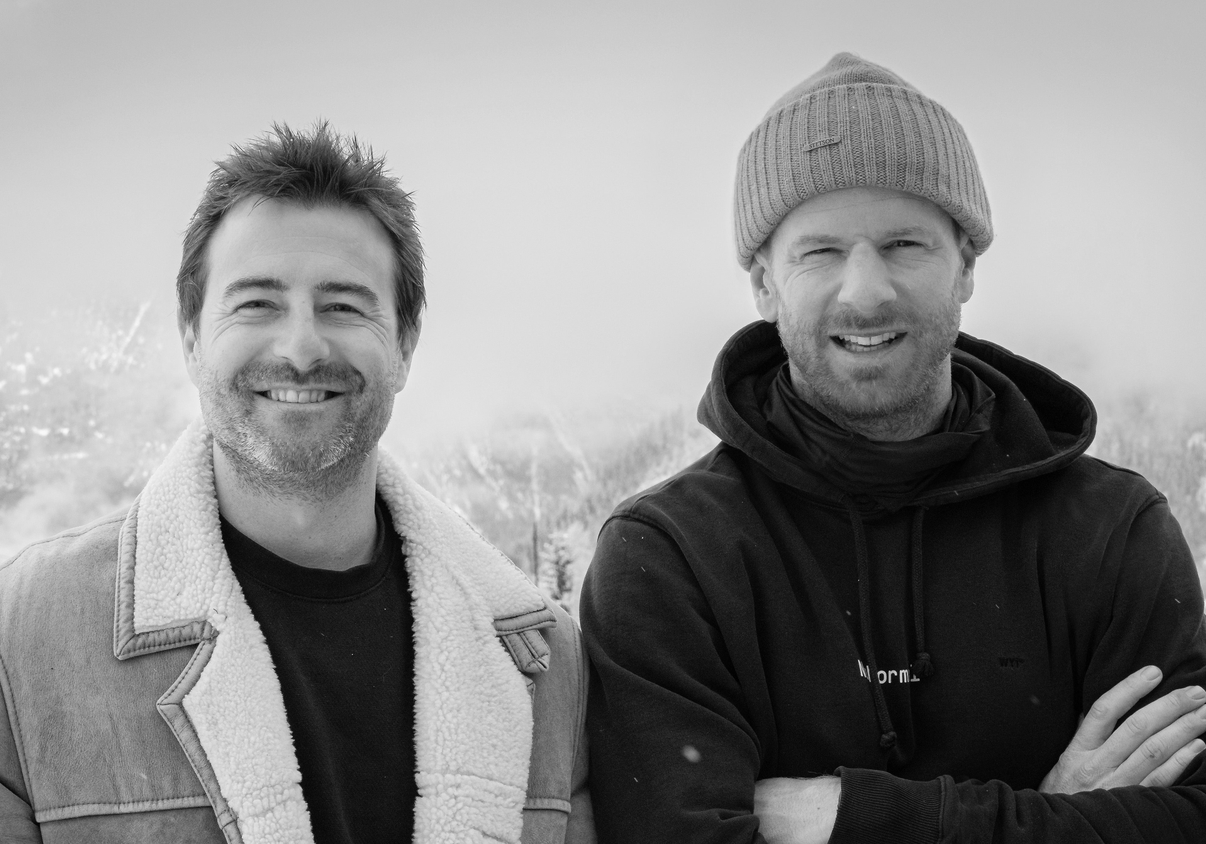 Two men standing side by side outdoors, wearing winter clothing.