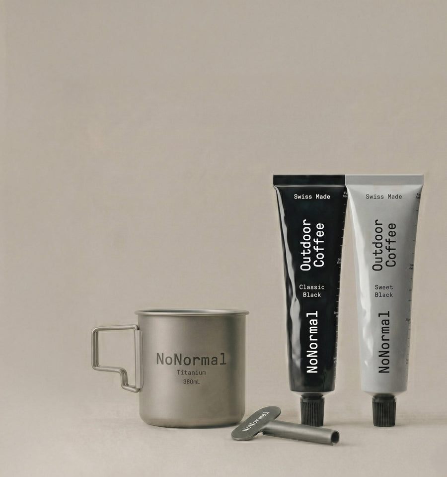 Two tubes of 'NoNormal' outdoor coffee and a metal mug on a beige background